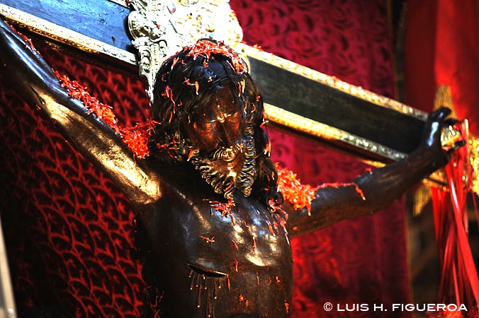 A crucifix during the Taytacha Temblores festival. Note the ñucchu flowers strewn upon it.